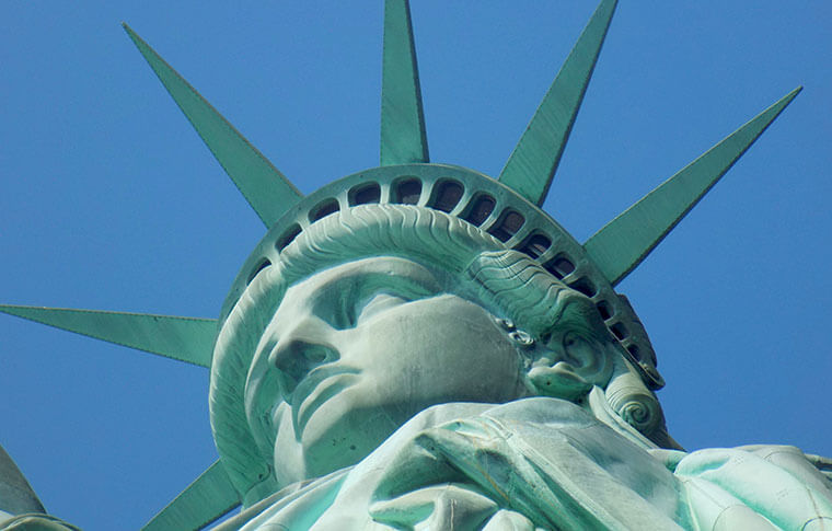statues of liberty head with blue sky behind